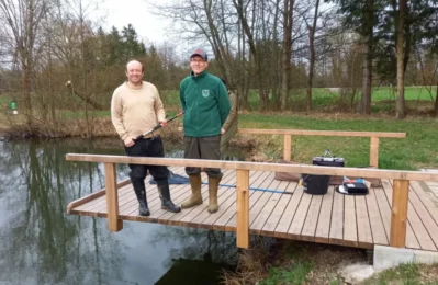 2 Personen auf einem Steg an einem Weiher